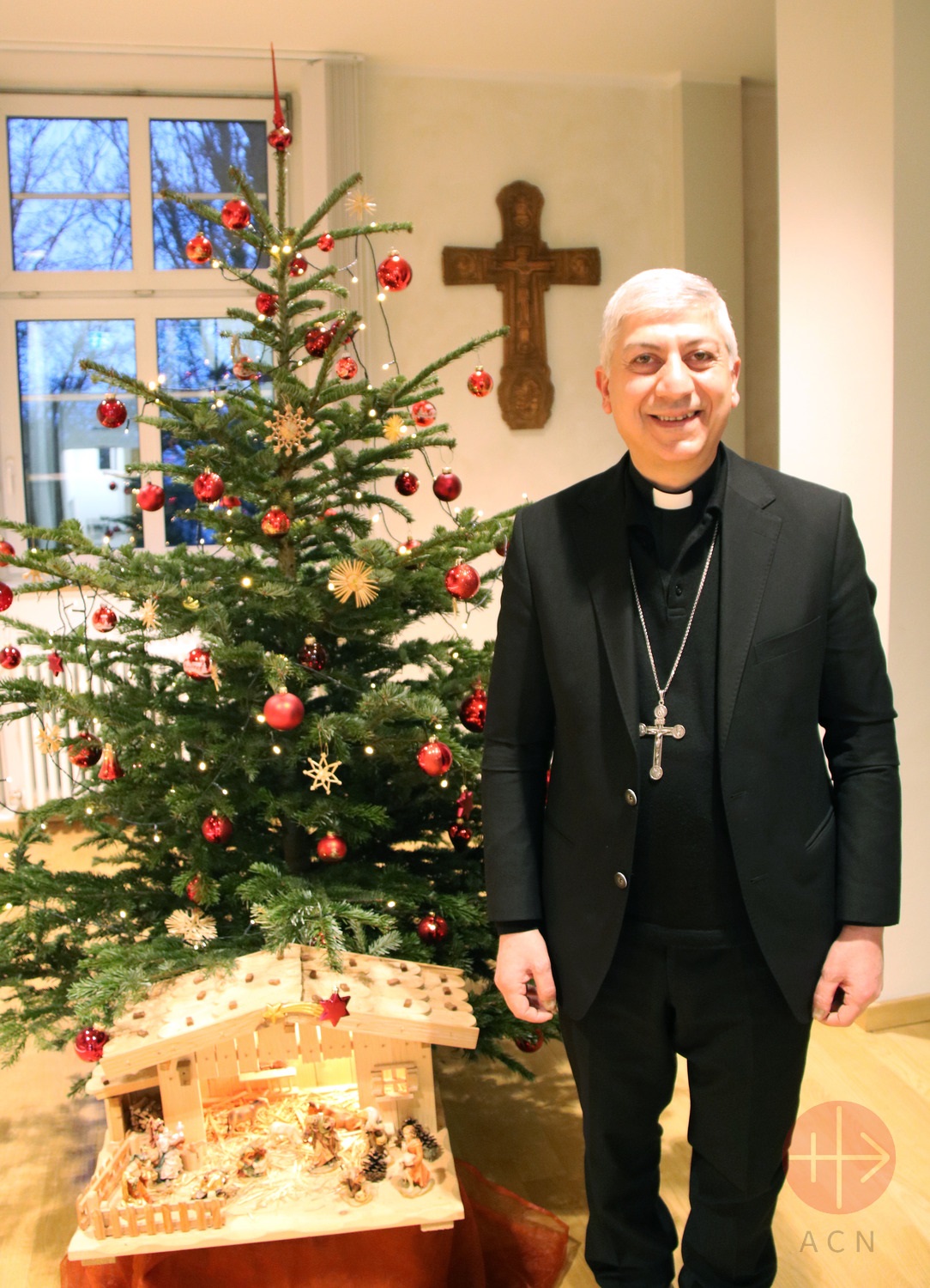SiriaArchbishop Joseph Tobji (Syria) next to the ACN Christmas tree and Christmas crib