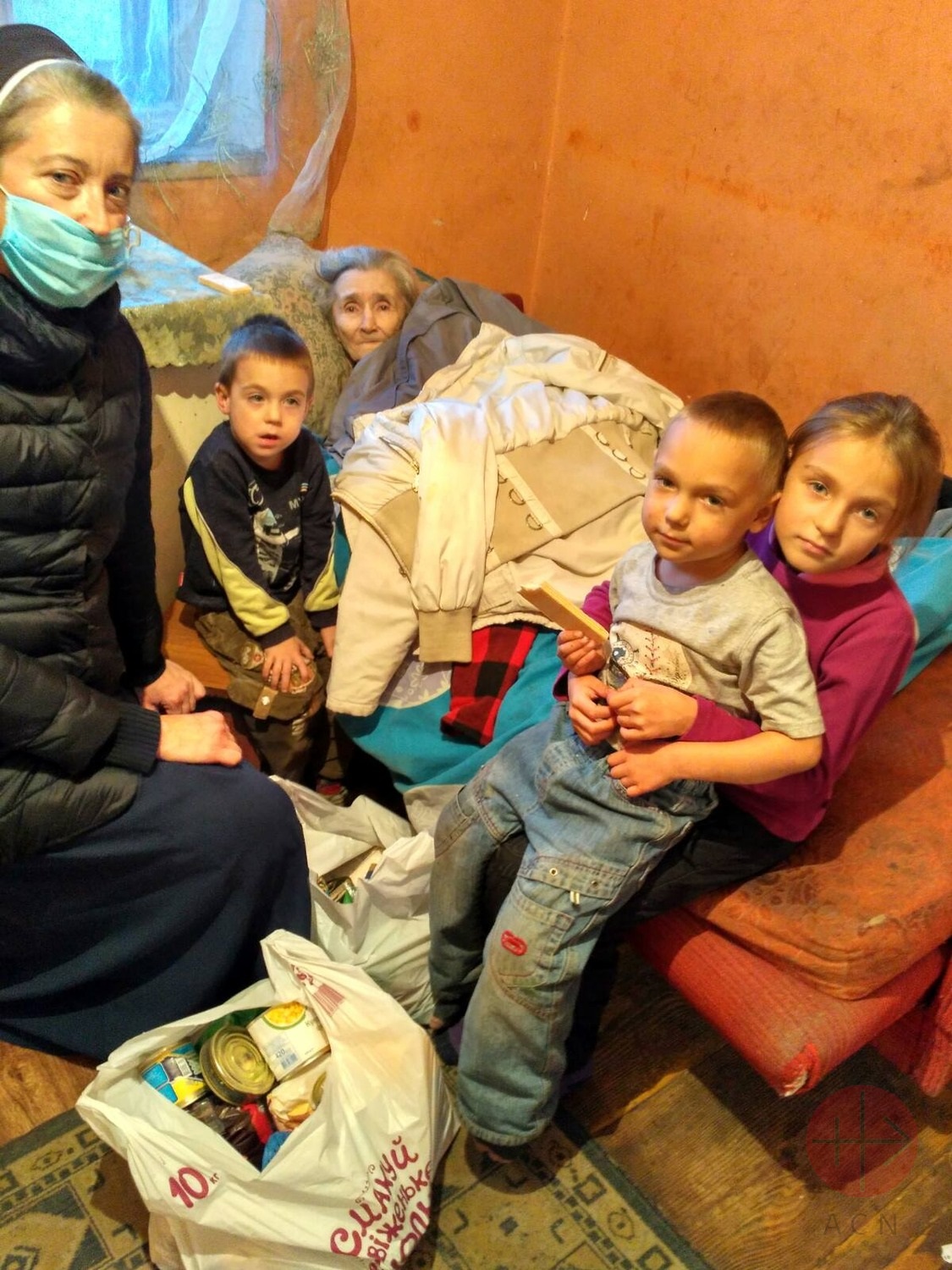 Ucrania religiosa con anciana y niños en cama