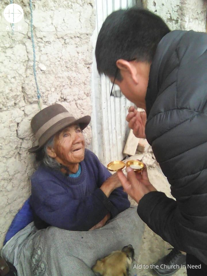 Perú proyecto julio sacerdote da comida a anciana