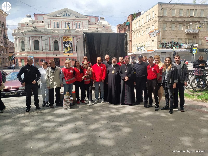 Ucrania el obispo Mytrofan el obispo Pavlo Honcharuk y el p. Wojciech Stasiewicz con voluntarios de Caritas frente al teatro en Kharkiv.