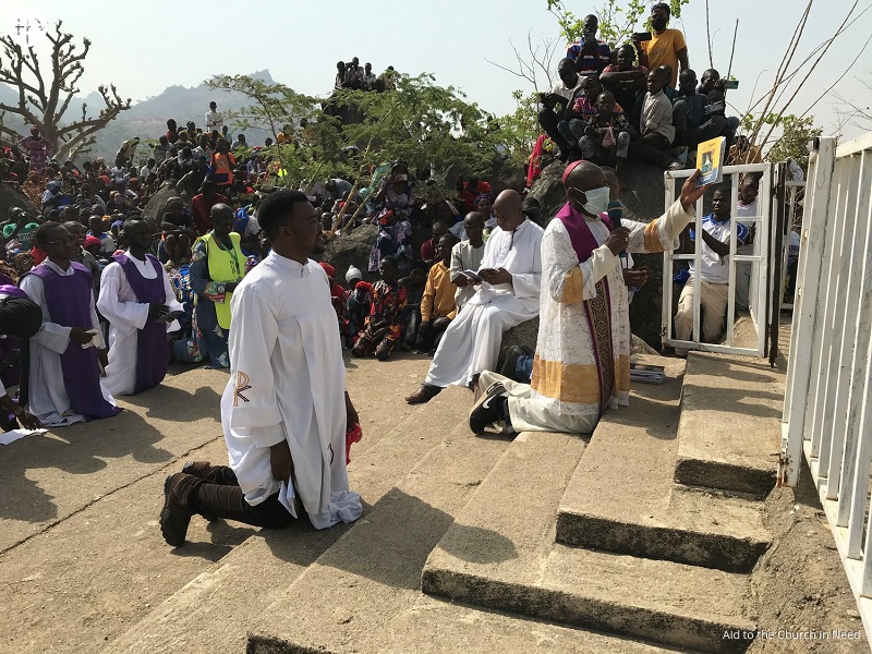 Nigeria De rodillas y orando con el obispo Oliver Dashe Doeme frente a la cruz